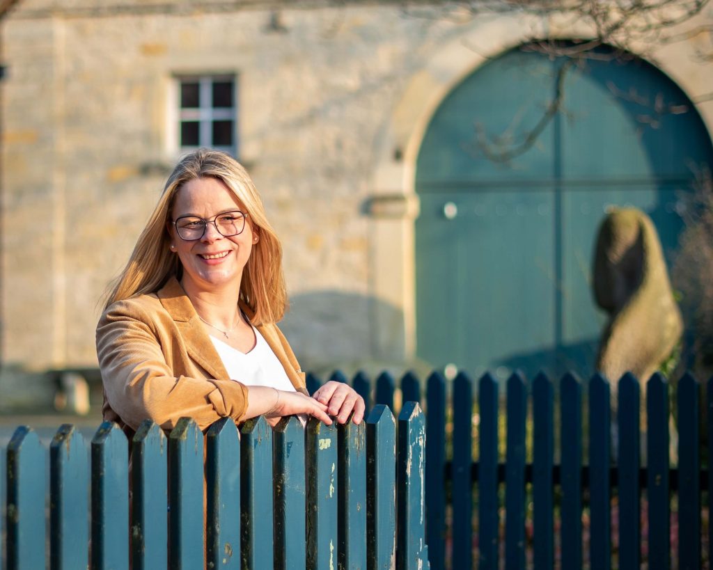 Geraldine Henneböhl, Bürgermeisterkandidatin für Havixbeck und Hohenholte,steht an einem Tor aus Holz am Baumberger Sandsteinmueseum.